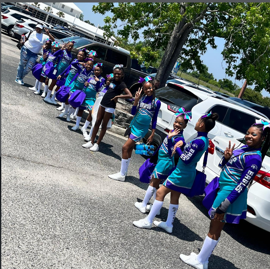 Diamond Eagles athletes and coach lined up outside in purple and teal uniforms before a competition