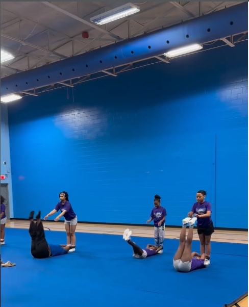 Athletes drilling stunt technique during practice in the training gym